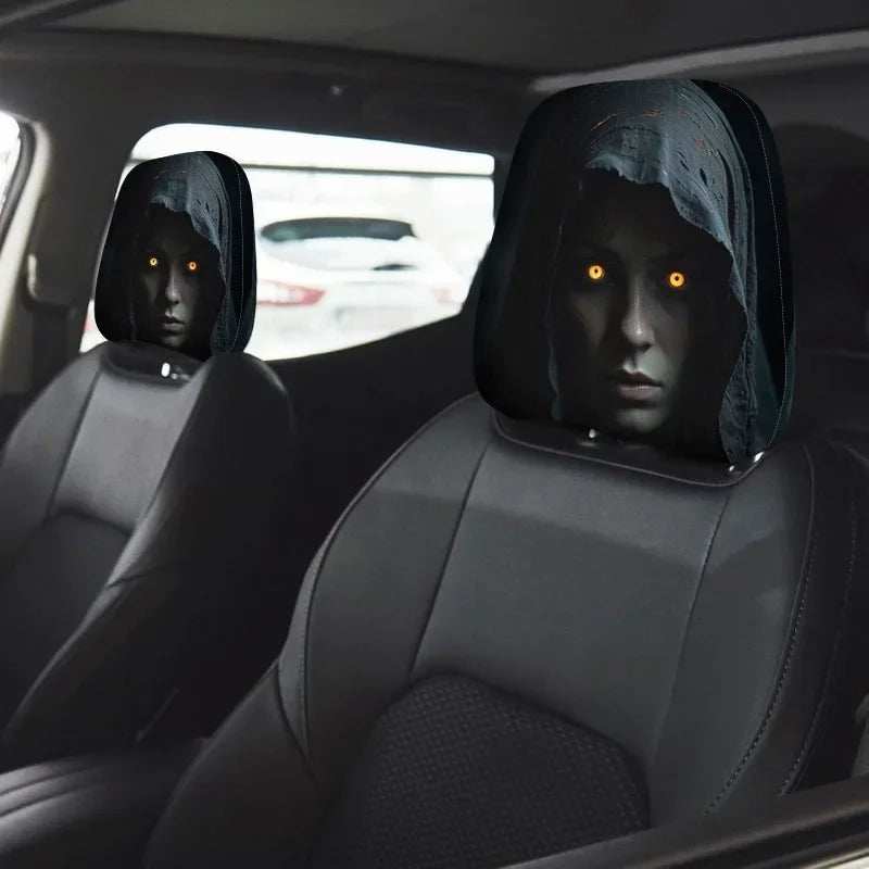 2Pcs Car Headrest Covers in black fabric with printed hooded faces and glowing orange eyes on car seats