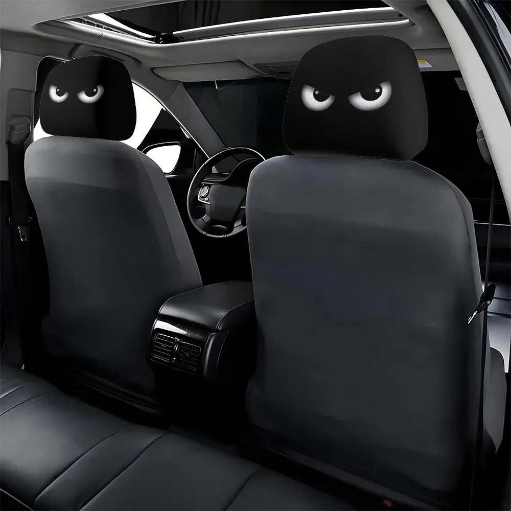 Funny Slanted Eyes car headrest covers in black fabric, each printed with a pair of white cartoon eyes